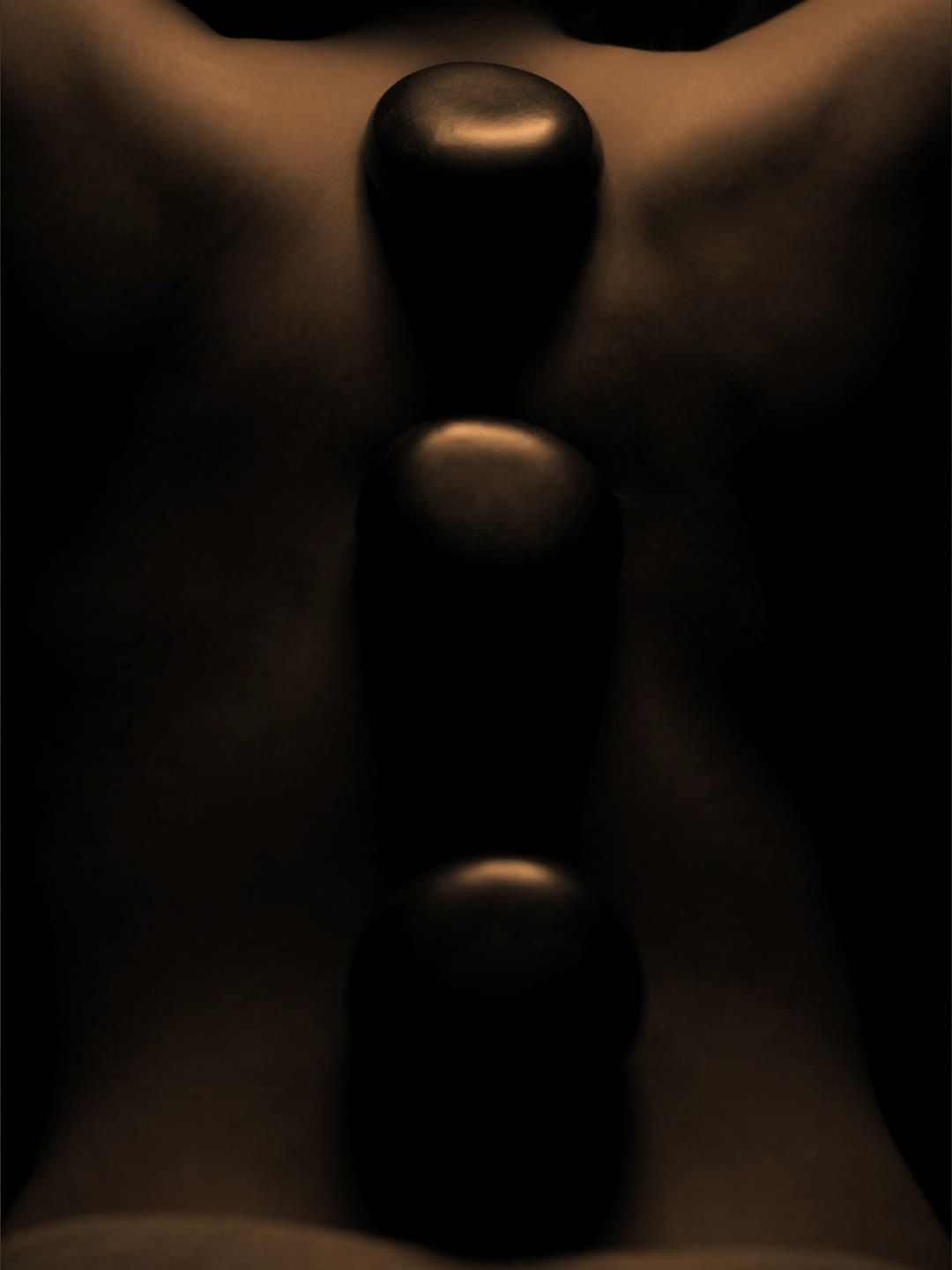 Heated stones laid along the spine during a hot stone massage